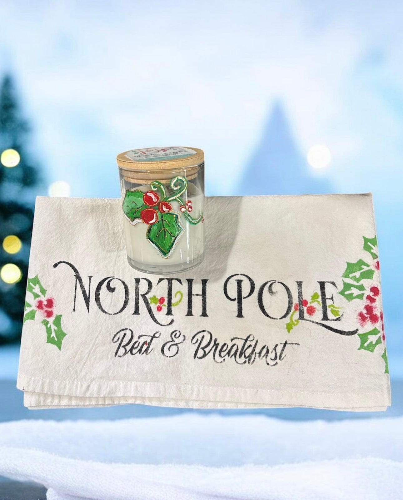 Decorative towel with 'North Pole Bed & Breakfast' text and a jar on a snowy background